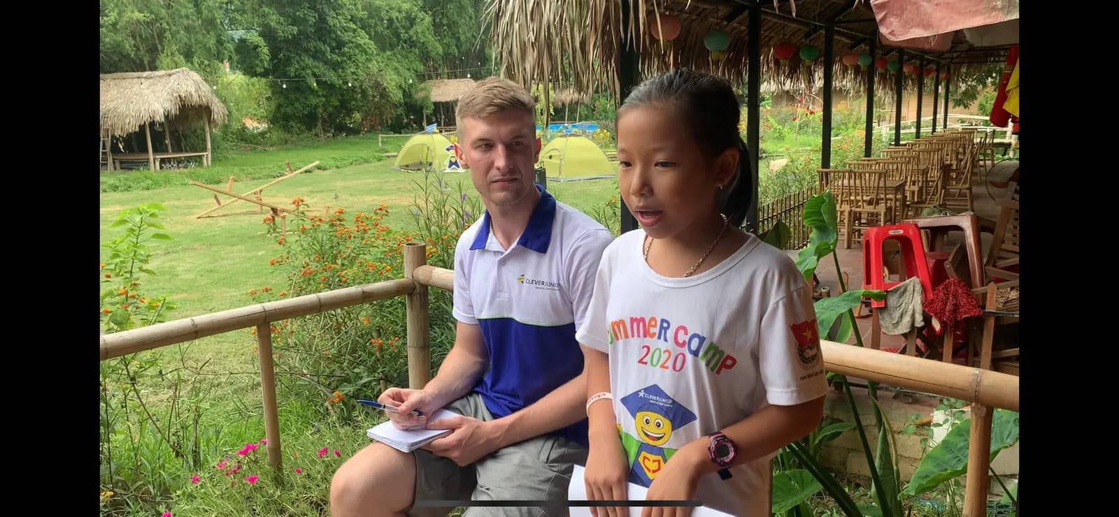 A native teacher talking with a student in English outdoors